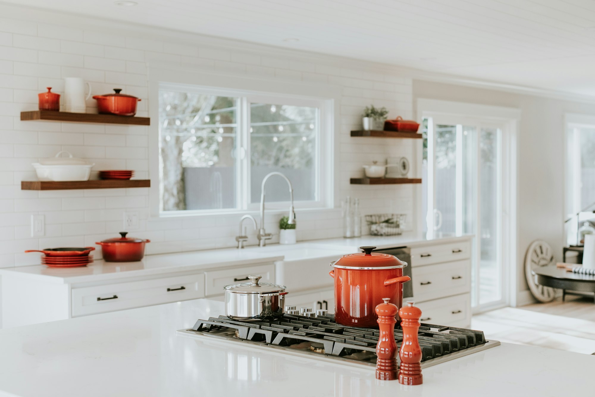 Close-up of stylish brushed metal kitchen cabinet pulls and knobs on white cabinets