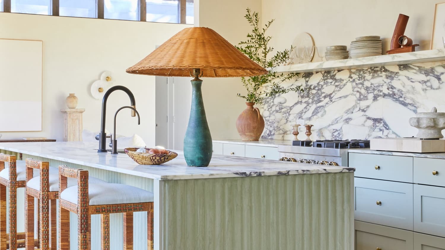 Full-height slab backsplash extending from countertop to ceiling in a modern kitchen