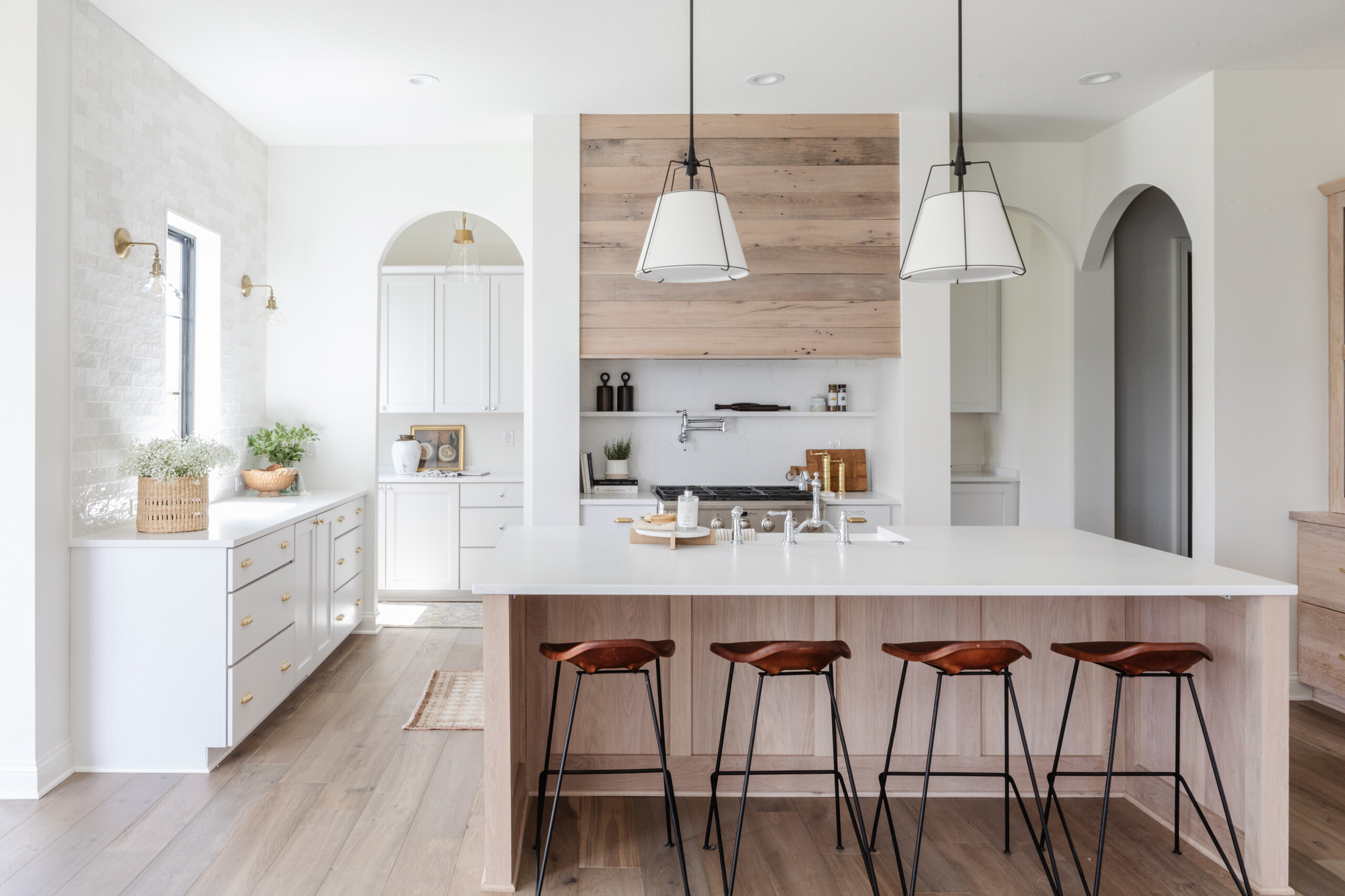 Elegant pendant lights hanging over a kitchen island providing layered ambient lighting