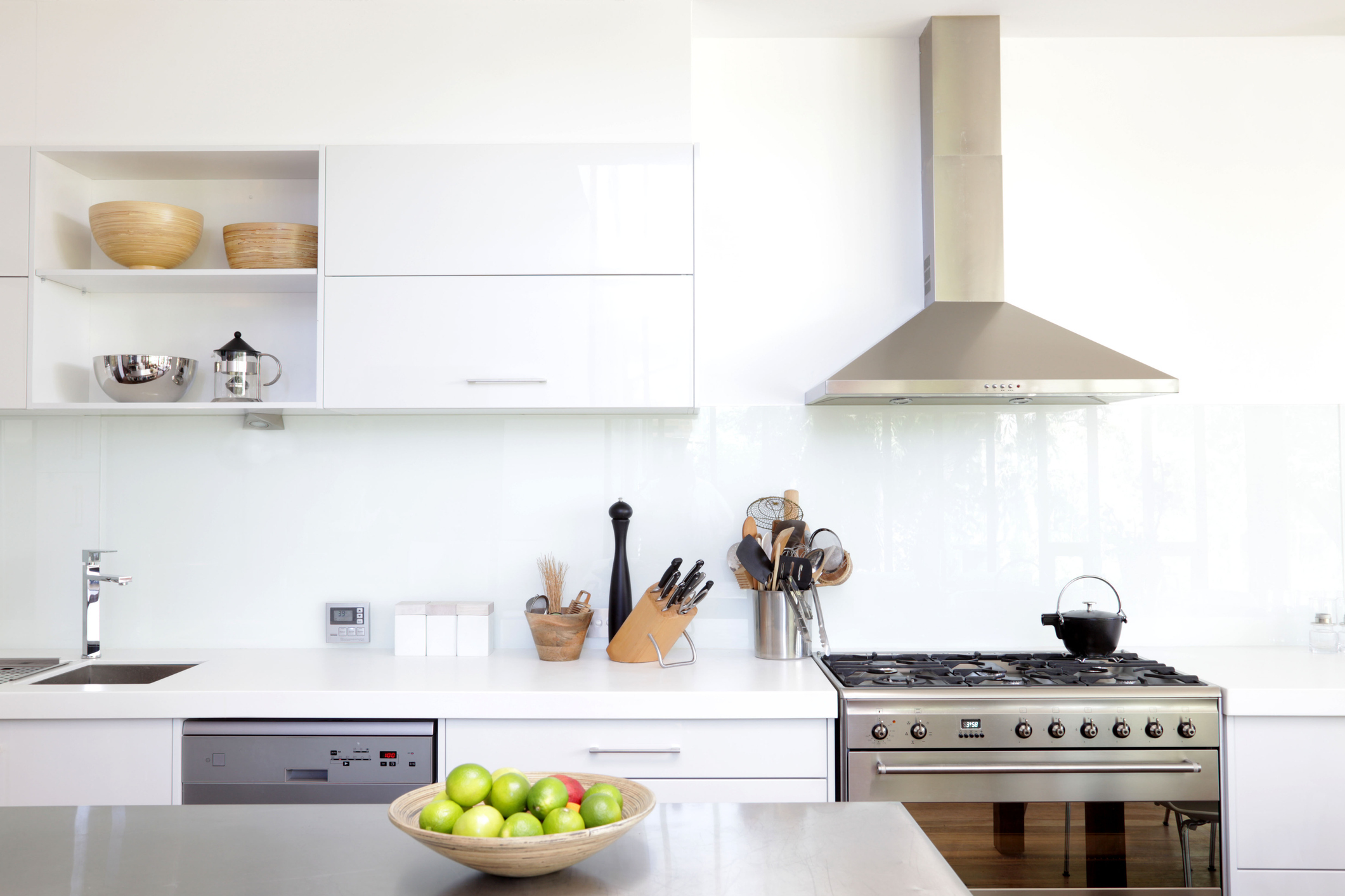 Professional stainless steel range hood installed above a cooktop in a kitchen